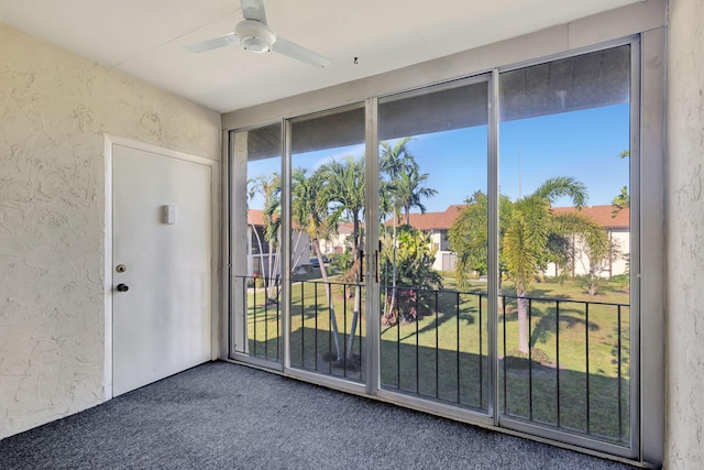 doorway to outside with carpet floors and ceiling fan