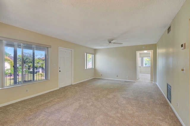 carpeted spare room with ceiling fan and a textured ceiling