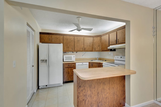 kitchen featuring ceiling fan, sink, kitchen peninsula, a textured ceiling, and white appliances