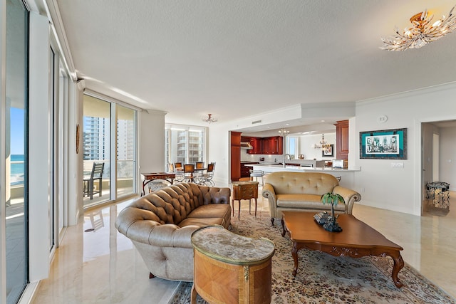 living room featuring an inviting chandelier, a water view, ornamental molding, expansive windows, and a textured ceiling