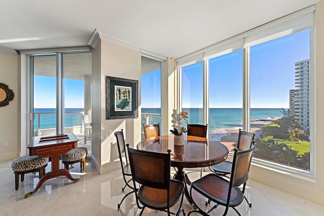 dining area featuring a water view and crown molding