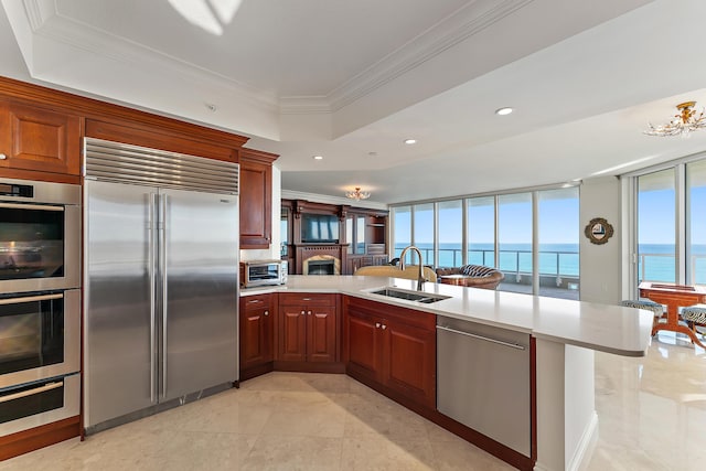 kitchen featuring crown molding, stainless steel appliances, kitchen peninsula, and a water view