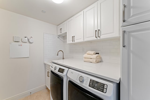 laundry room featuring cabinets, sink, washer and dryer, and light tile patterned floors