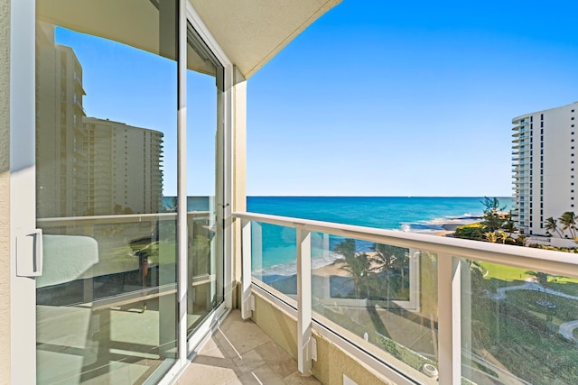 balcony featuring a beach view and a water view