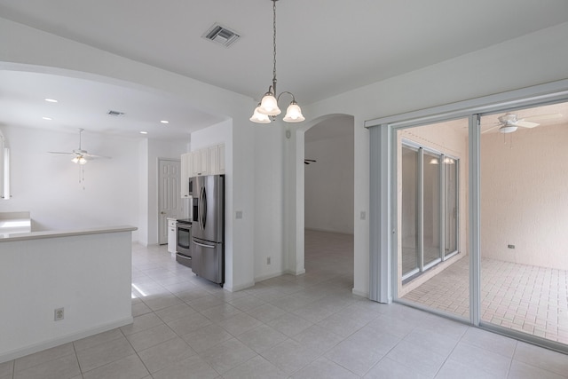 interior space with ceiling fan with notable chandelier and light tile patterned floors