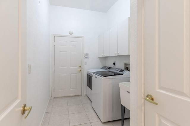 laundry room with cabinets, washer and dryer, and light tile patterned floors