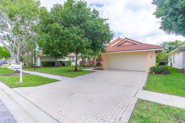 view of front of property featuring central AC unit, a garage, and a front lawn