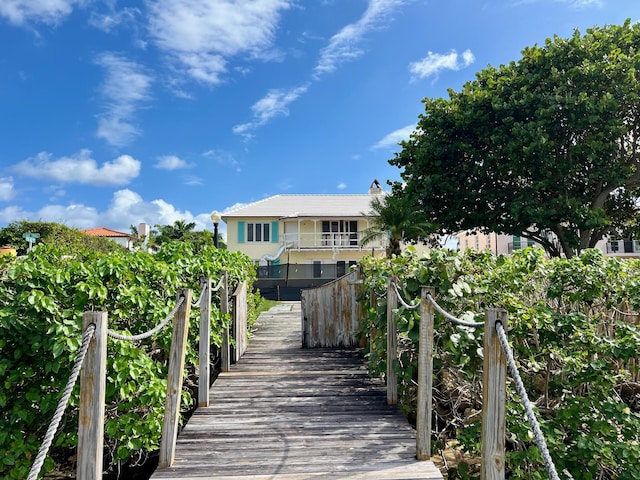 rear view of property featuring a balcony and a yard