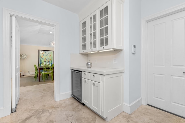 kitchen featuring white cabinetry, beverage cooler, and crown molding