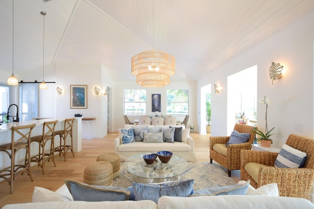 living room with sink, light hardwood / wood-style floors, vaulted ceiling, and wood ceiling