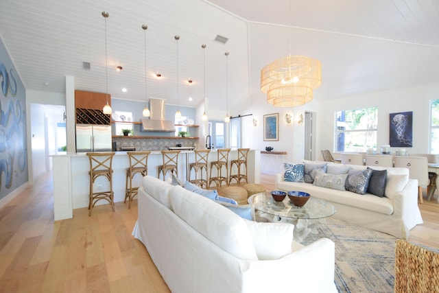 living room with wood ceiling, light wood-type flooring, high vaulted ceiling, and an inviting chandelier