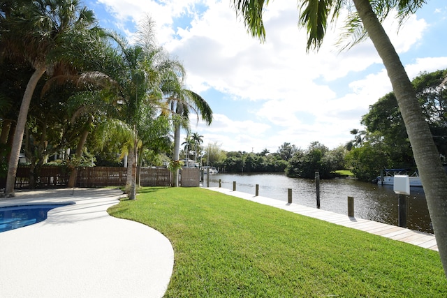 exterior space featuring a water view, a fenced in pool, and a dock