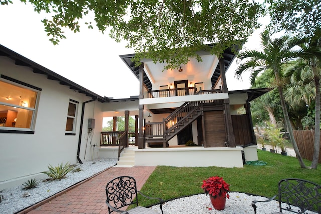 back of house featuring a patio, a balcony, and a lawn