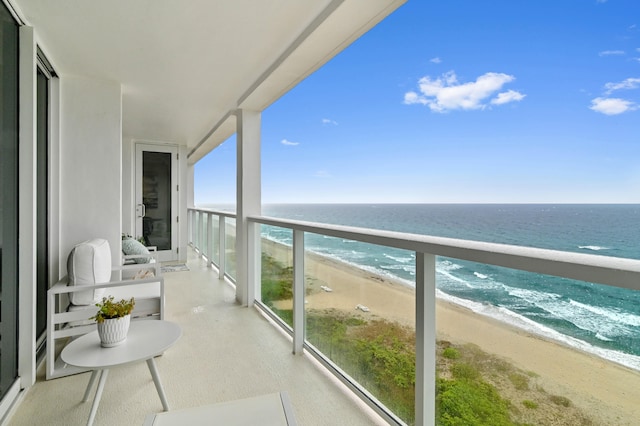 balcony with a water view and a view of the beach