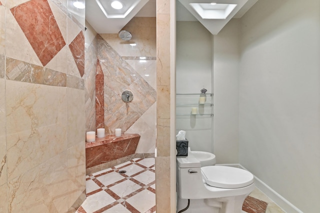 bathroom with toilet, a tile shower, and tile patterned floors