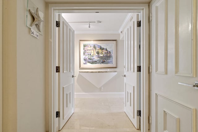 hall featuring rail lighting and crown molding