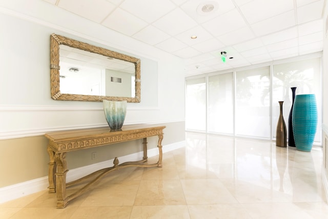 misc room with a paneled ceiling and light tile patterned floors