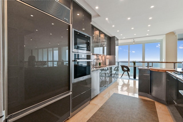 kitchen featuring sink, a water view, stainless steel appliances, and light tile patterned floors