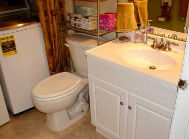 bathroom featuring tile patterned floors, vanity, and toilet