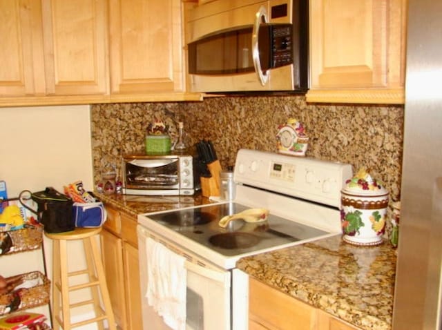 kitchen with light stone countertops, light brown cabinets, electric range, and tasteful backsplash