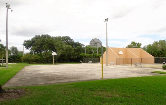 surrounding community featuring community basketball court, a yard, and fence