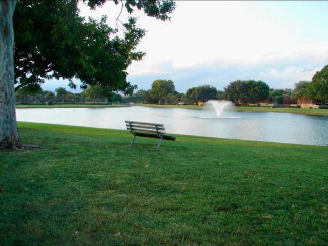 exterior space with a water view and a lawn