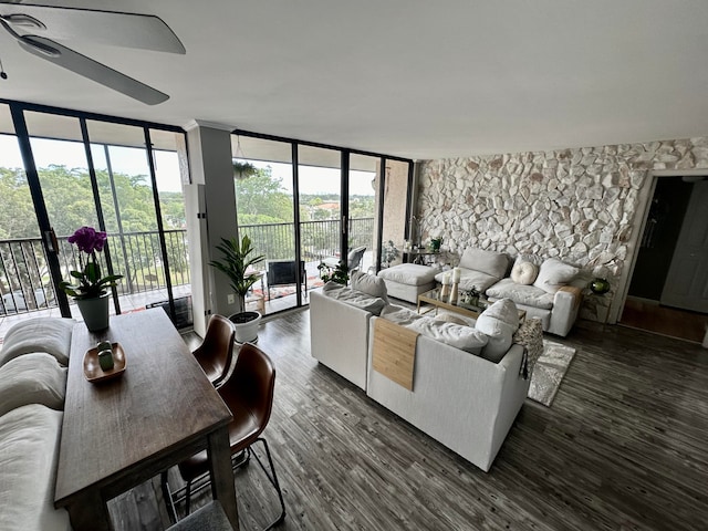 living room with ceiling fan, plenty of natural light, dark hardwood / wood-style floors, and a wall of windows