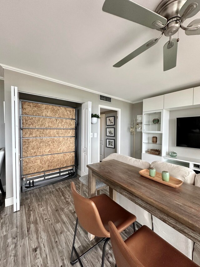 unfurnished dining area featuring dark hardwood / wood-style flooring, ceiling fan, and ornamental molding