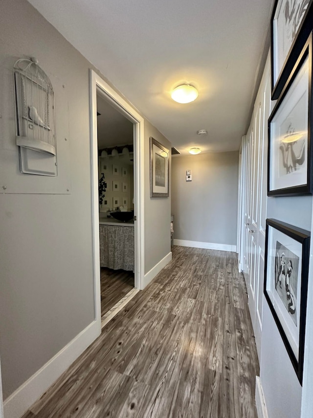 hallway with hardwood / wood-style flooring