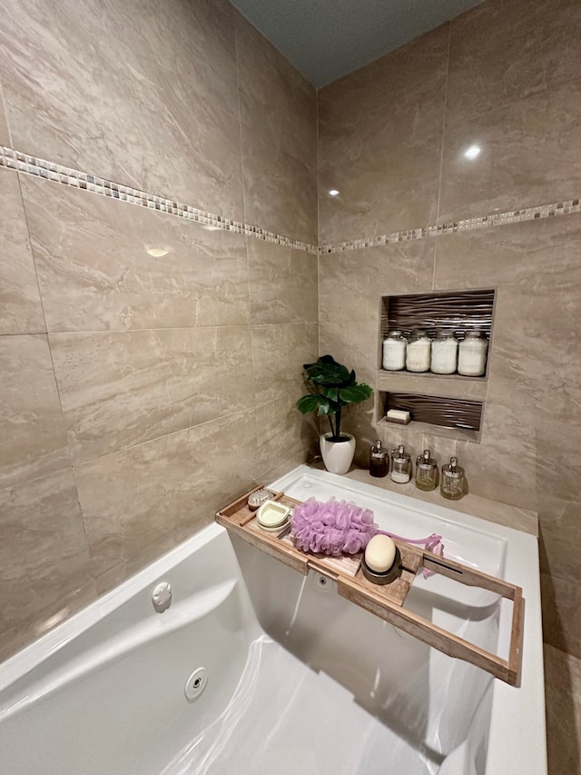 bathroom featuring a bathtub and tile walls