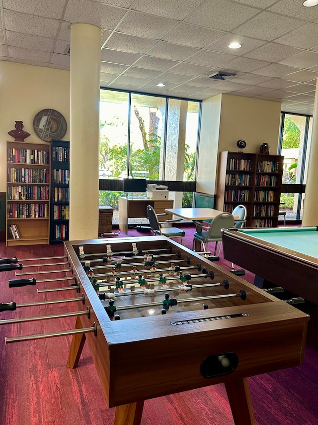 recreation room featuring a paneled ceiling, carpet flooring, and a wealth of natural light