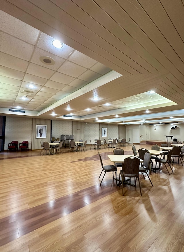 dining area with a paneled ceiling and light hardwood / wood-style flooring