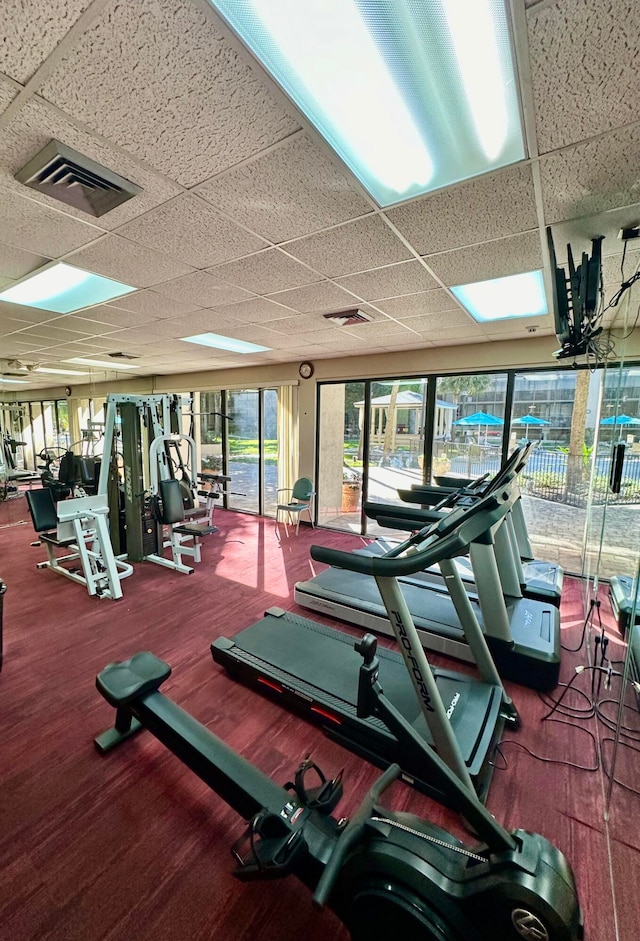 workout area featuring a drop ceiling and wood-type flooring