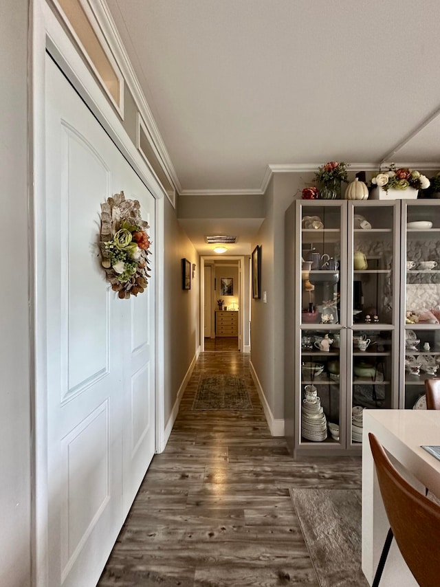 hall with dark hardwood / wood-style floors and ornamental molding