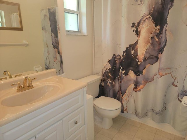 bathroom with toilet, vanity, and tile patterned floors