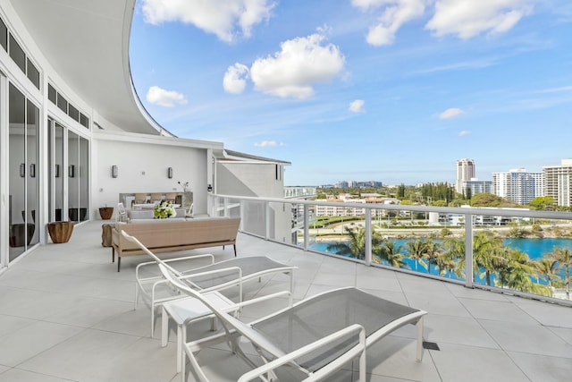 balcony featuring a water view and an outdoor living space