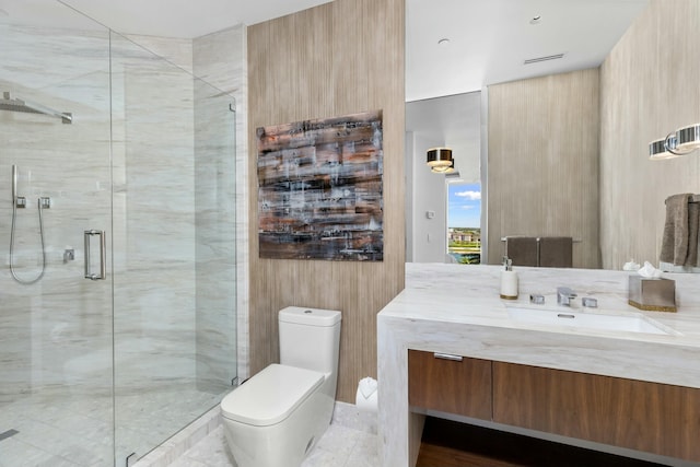 bathroom with vanity, toilet, and a shower with door