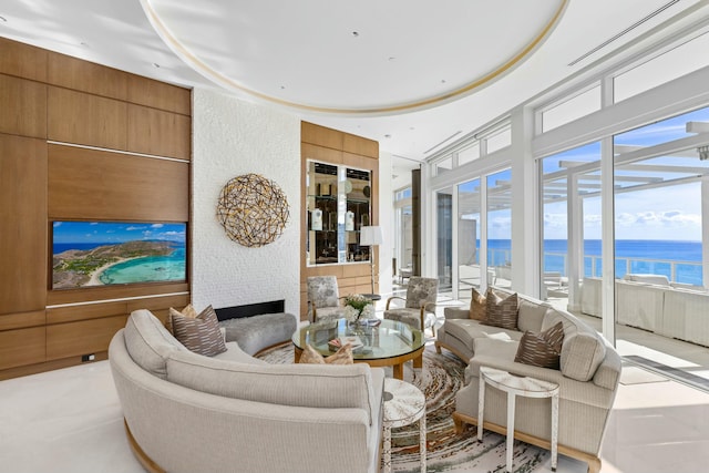 living room featuring a large fireplace and a water view