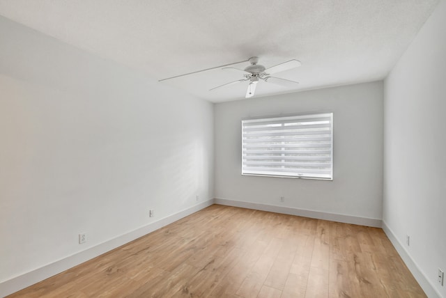 empty room featuring ceiling fan, light hardwood / wood-style flooring, and a textured ceiling