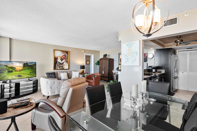 dining space with ceiling fan with notable chandelier, light tile patterned floors, and a textured ceiling