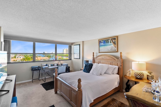 bedroom featuring light carpet and a textured ceiling