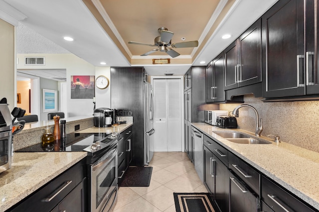 kitchen featuring light stone counters, sink, light tile patterned floors, and stainless steel appliances