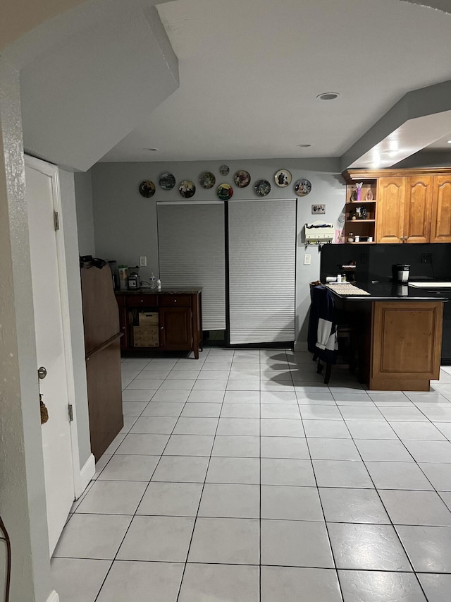 20 Laredo Pl Unit 2-1, Davie, FL 33324 - kitchen with open shelves, dark countertops, light tile patterned flooring, and brown cabinetry