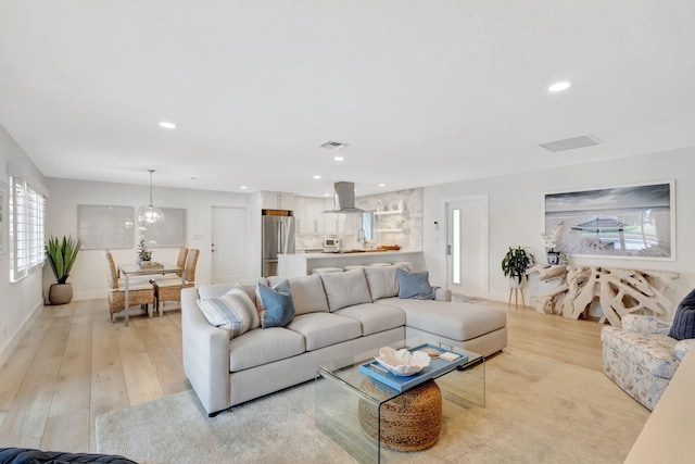 living room with light wood-type flooring and sink