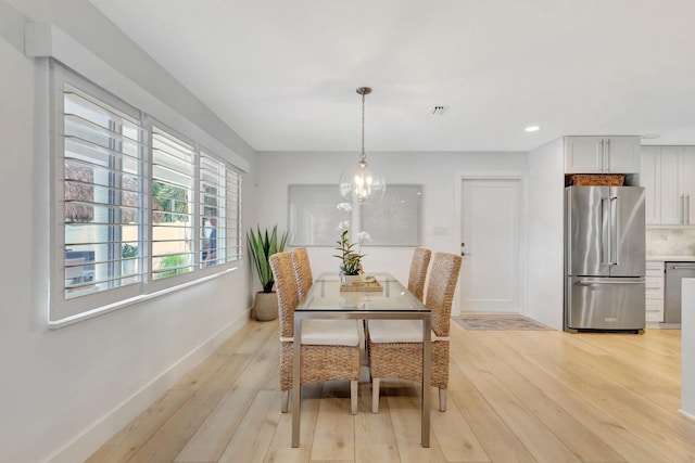 dining space with an inviting chandelier and light wood-type flooring