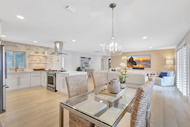 dining room featuring a notable chandelier, light hardwood / wood-style floors, and sink