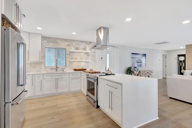 kitchen featuring island exhaust hood, stainless steel appliances, white cabinets, and light hardwood / wood-style floors