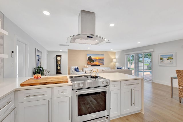 kitchen featuring island exhaust hood, electric range, white cabinets, and light hardwood / wood-style floors