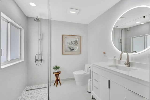 bathroom featuring tiled shower, vanity, and toilet