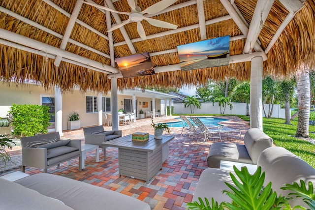 view of patio with a gazebo, ceiling fan, a fenced in pool, and an outdoor hangout area